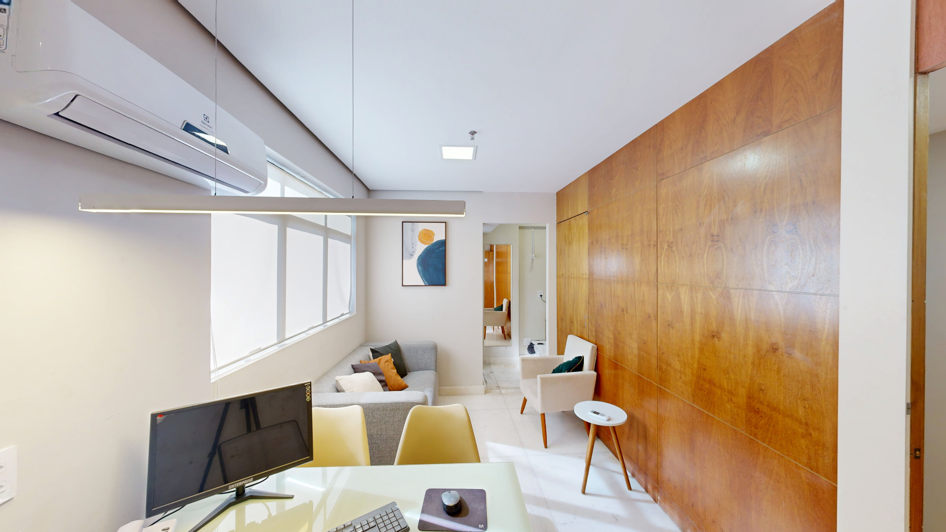 Consultório com sala de espera integrada e painel de madeira