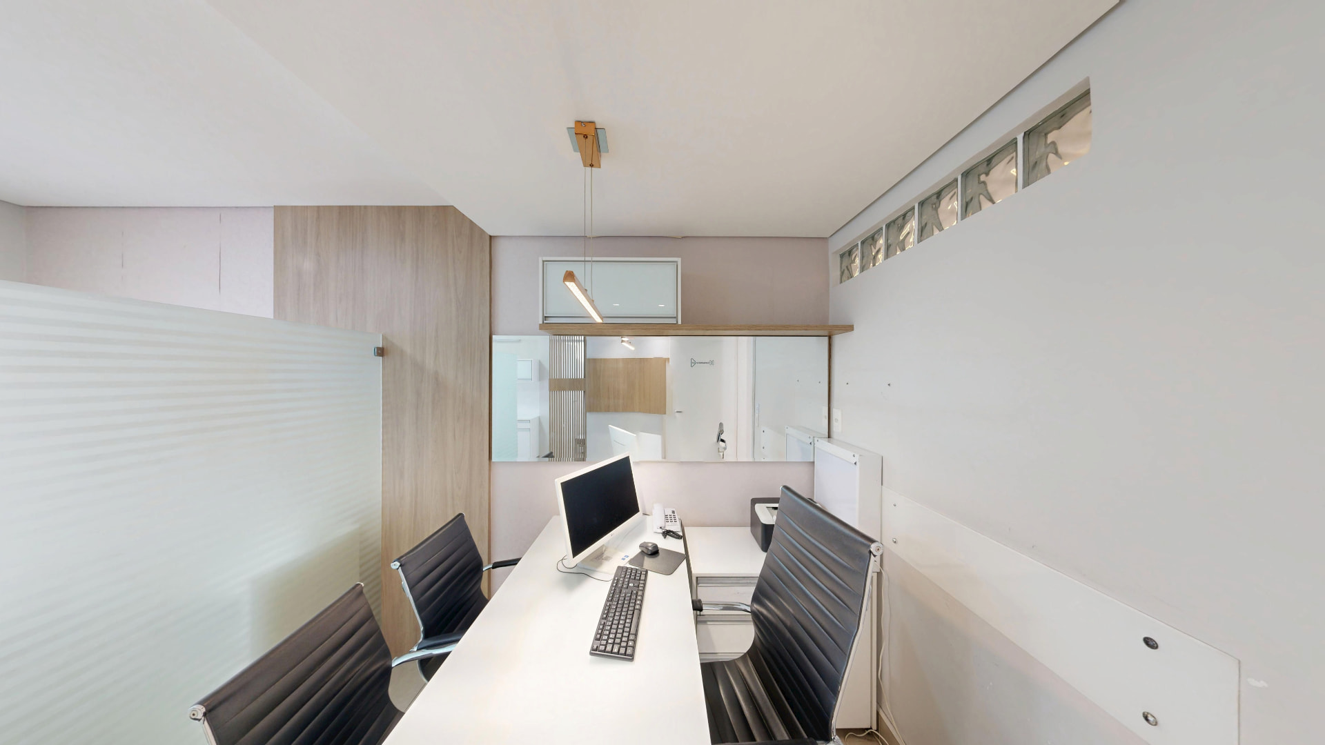 Sala administrativa com bancada e estações de trabalho